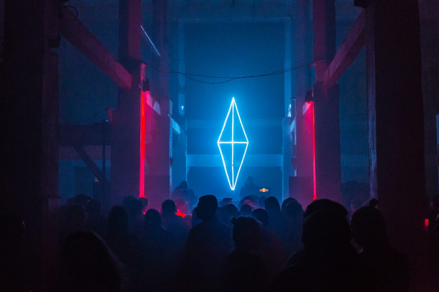 a group of people standing in front of a neon sign
