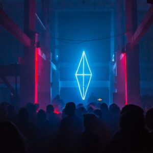 a group of people standing in front of a neon sign